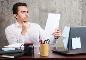 Young businessman looking work papers at the office desk. High quality photo
